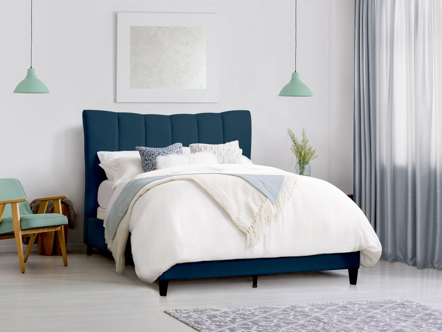 Navy blue channel tufted queen bed with plush velvet upholstery and sleek wooden legs.