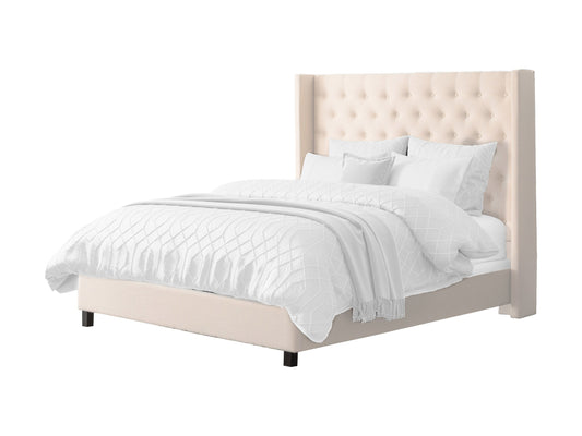 Cream tufted king bed with slats, upholstered headboard, and wooden legs.