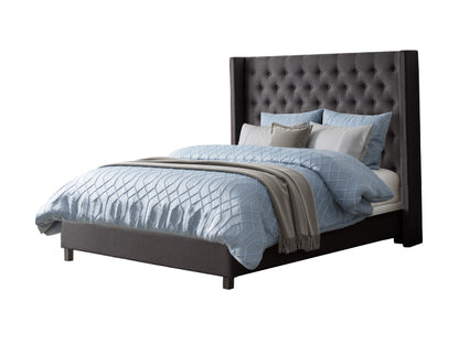 Dark grey tufted king bed with upholstered headboard, wooden legs, and minimalist design.