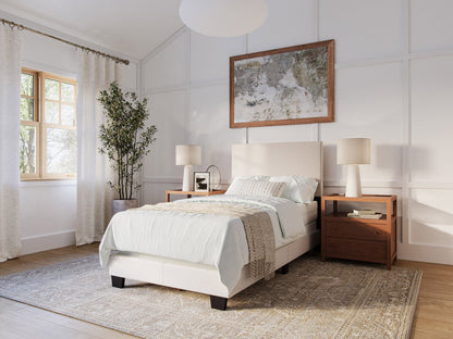 Beige twin bed with wooden legs, upholstered headboard, and minimalist design, ideal for modern bedrooms.