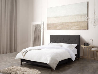 Dark grey button tufted double bed with upholstered headboard and wooden legs.