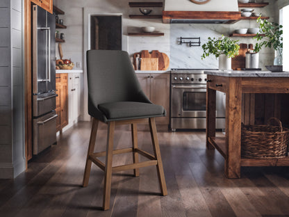 Dark grey modern bar stools with fabric seats and black metal legs in a contemporary kitchen setting.