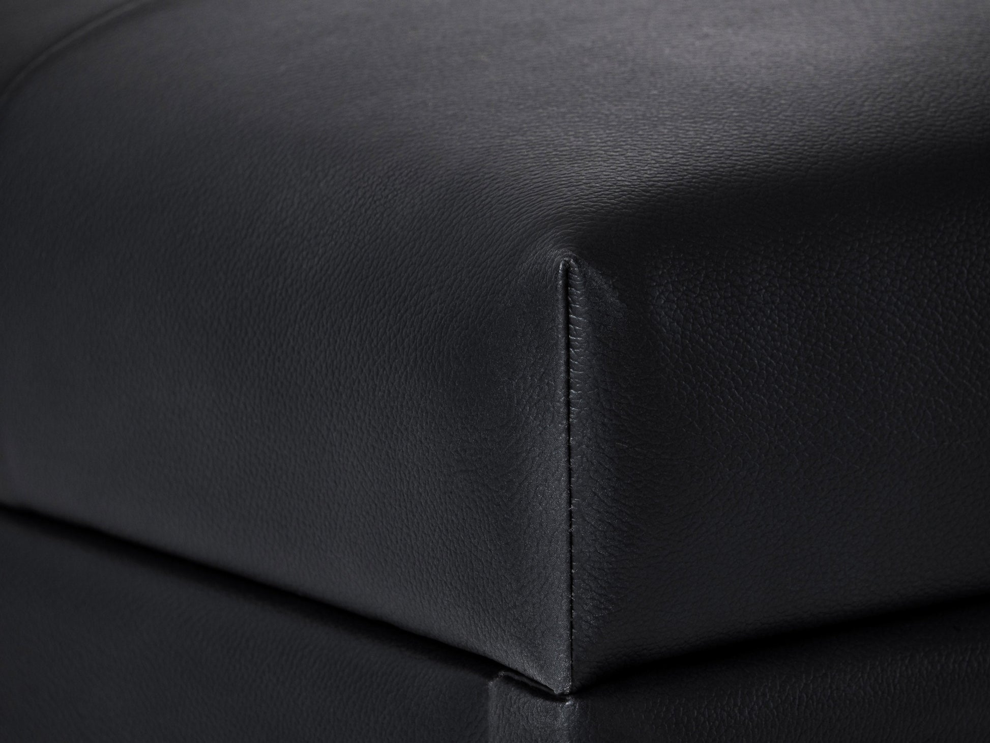 Black vegan leather storage ottoman with tufted top, sleek design, and hidden storage compartment.