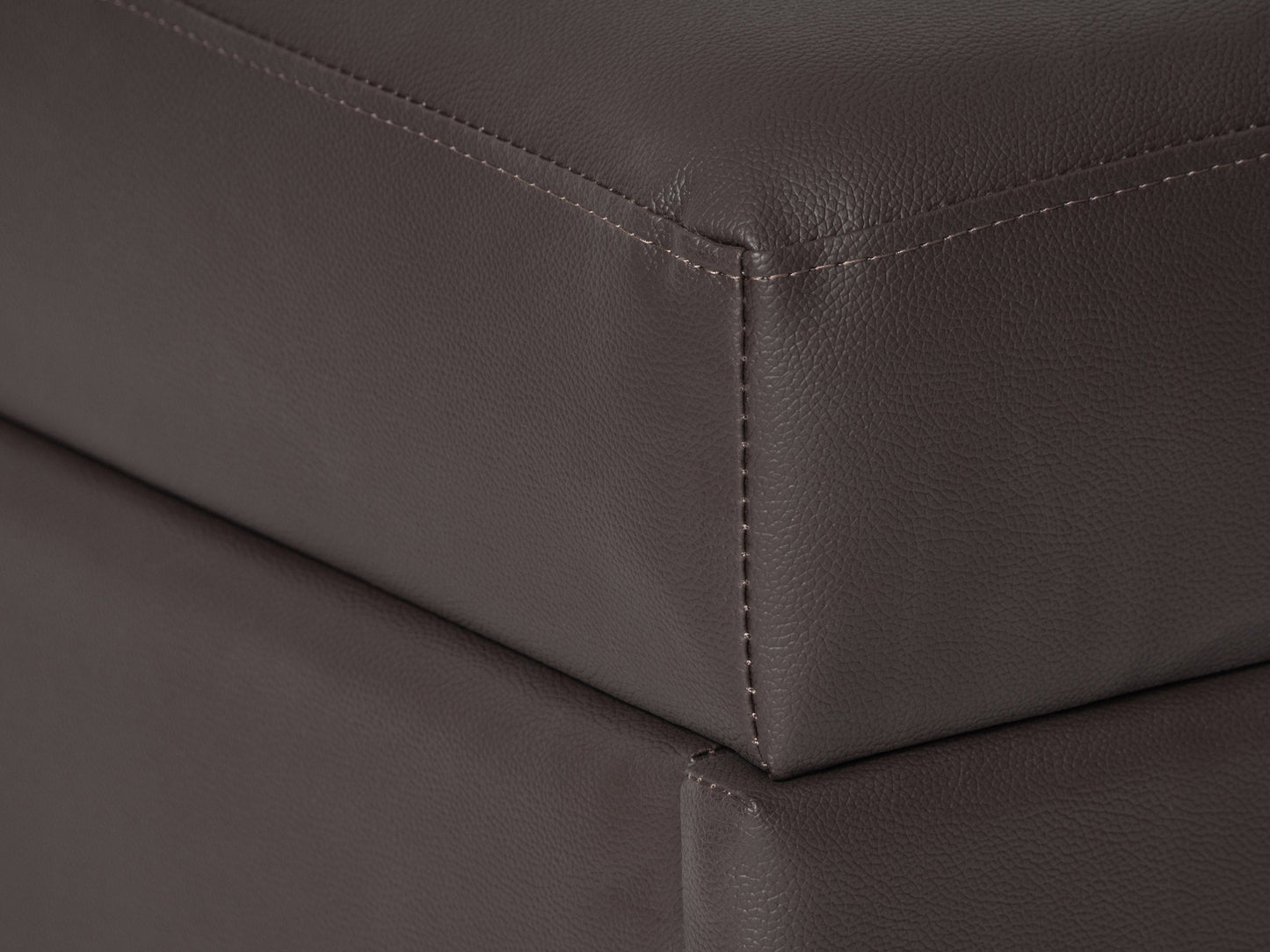 Brown vegan leather storage ottoman with tufted top and wooden legs.