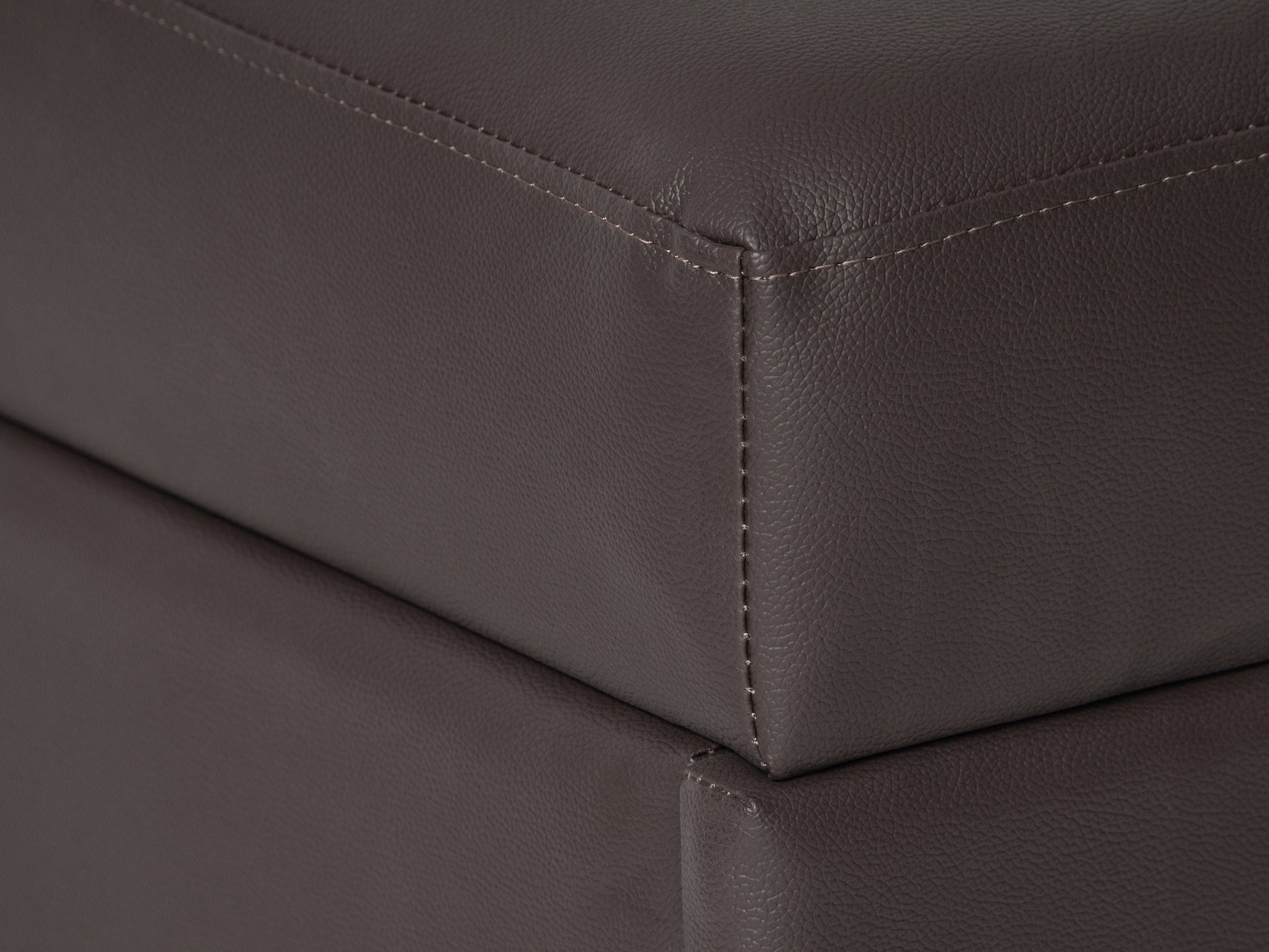 Brown vegan leather storage ottoman with tufted top and wooden legs.