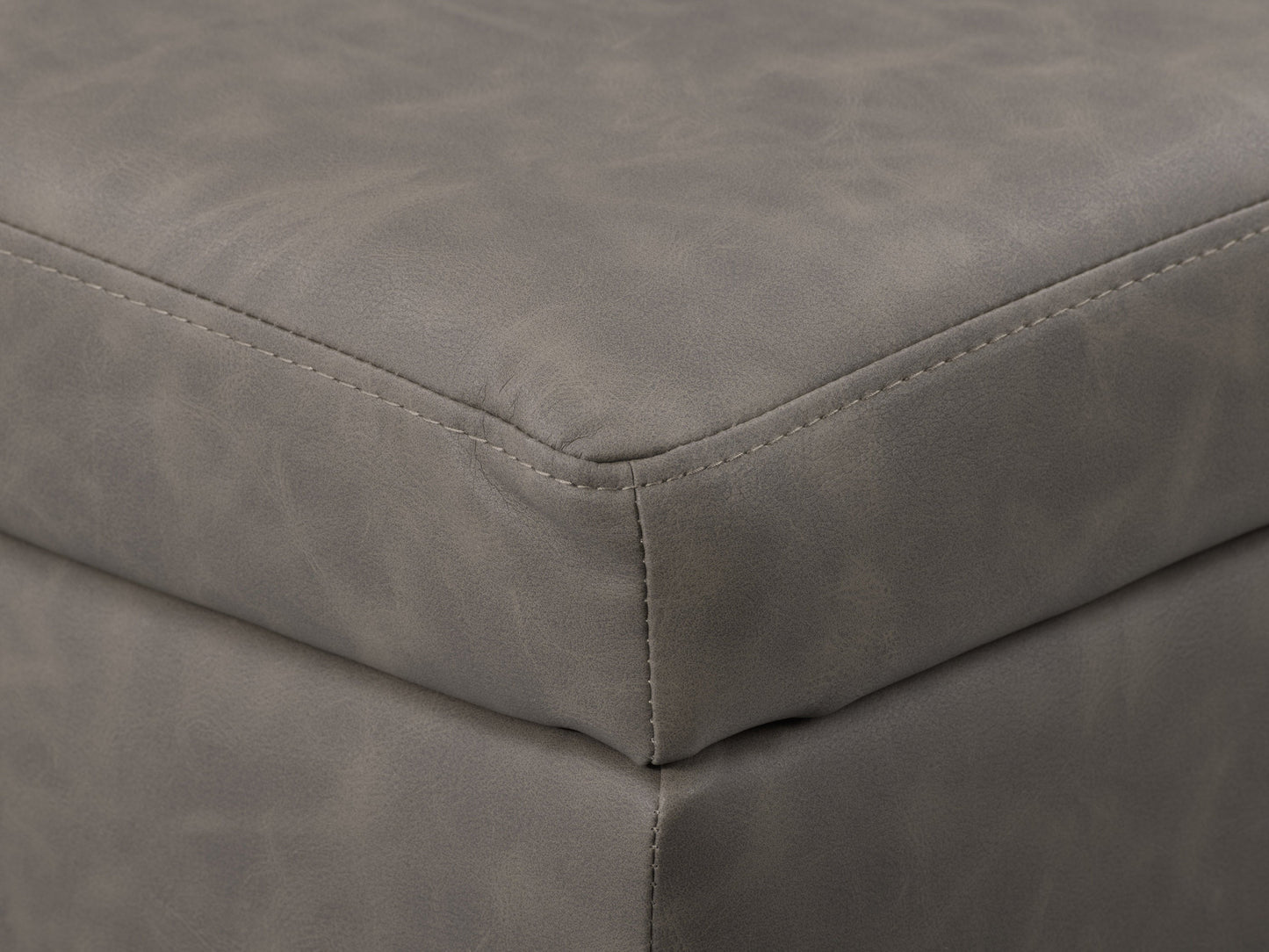 Mid-century modern grey ottoman with tufted fabric, wooden legs, and minimalist design.