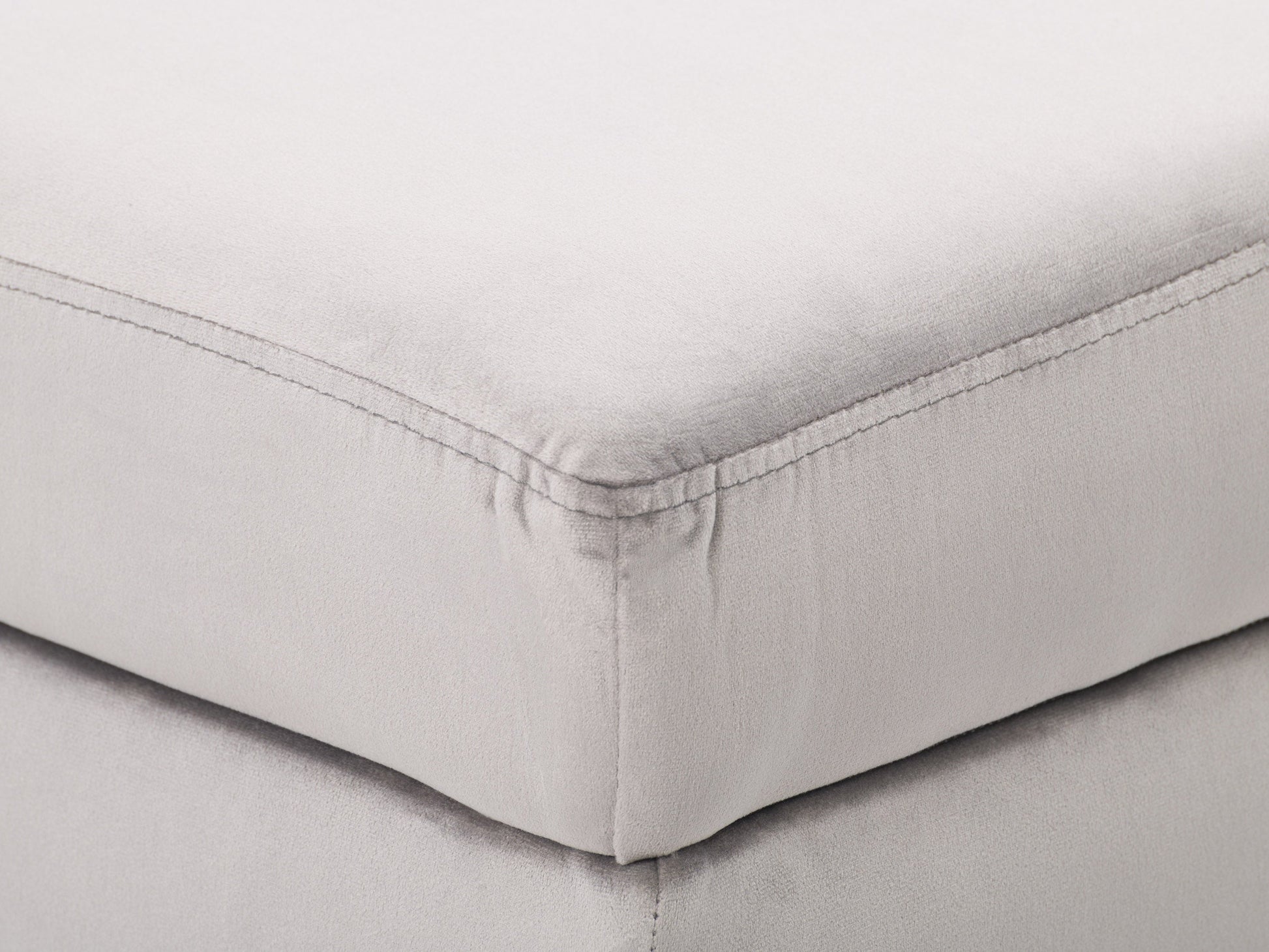 Light grey velvet storage ottoman with tufted top and wooden legs.