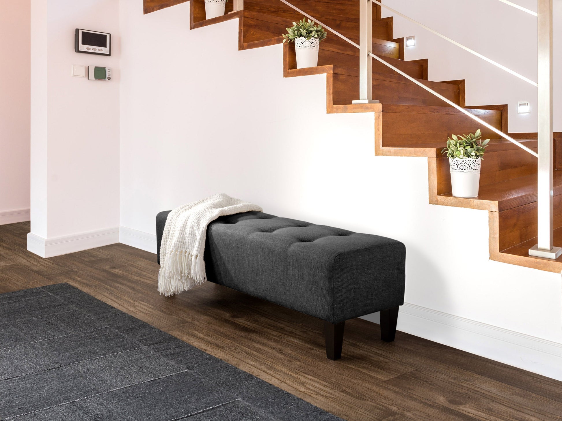 Dark grey accent bench with wooden legs, tufted fabric upholstery, and modern minimalist design.