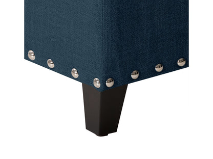 Navy blue tufted storage ottoman with wooden legs and soft fabric upholstery.