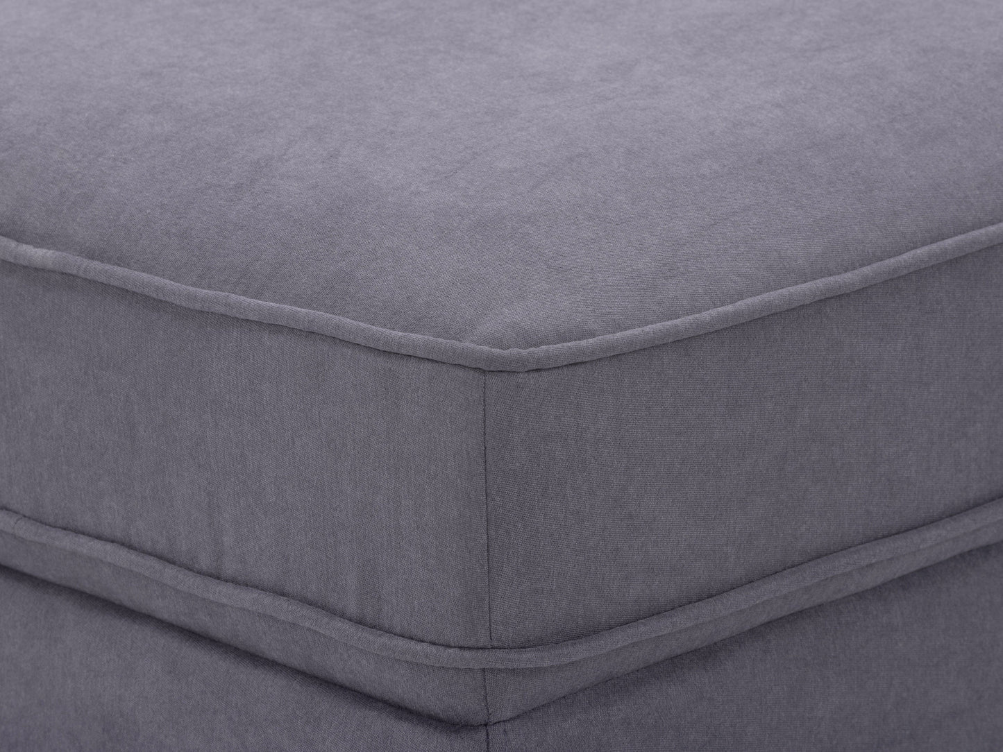 Mid-century modern grey ottoman with wooden legs and tufted fabric upholstery.