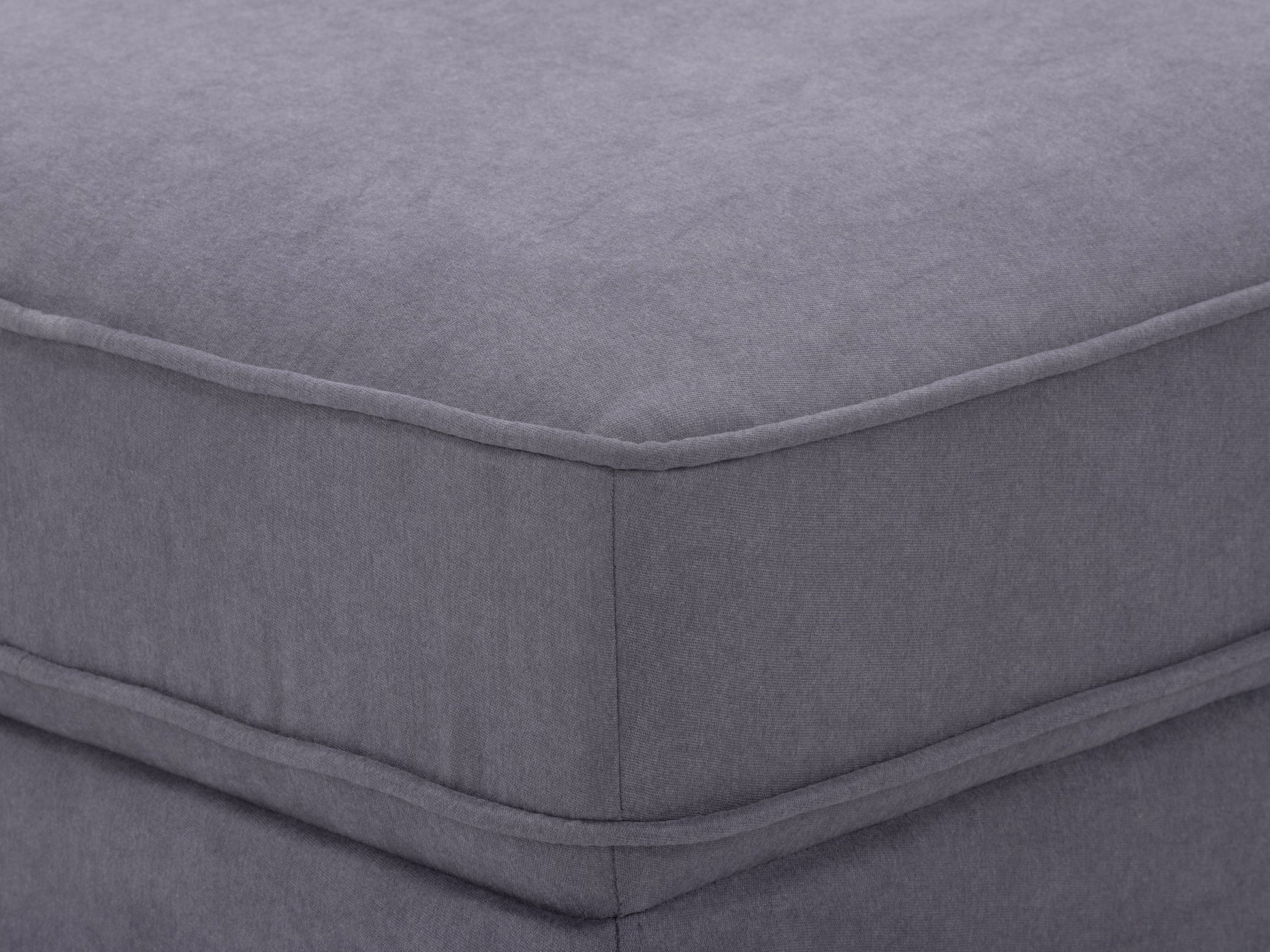 Mid-century modern grey ottoman with wooden legs and tufted fabric upholstery.