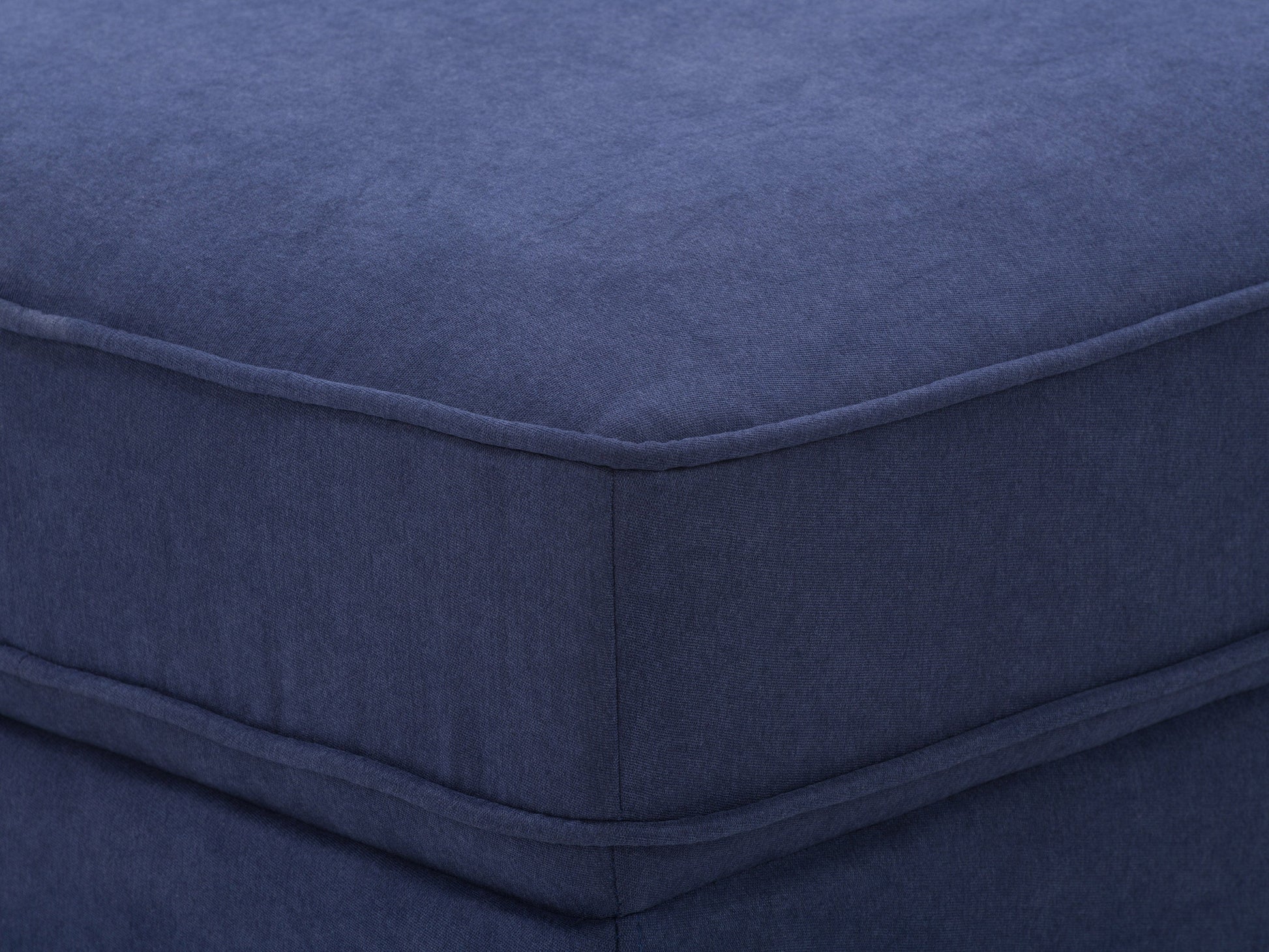 Navy blue mid-century modern ottoman with tufted fabric and wooden legs.