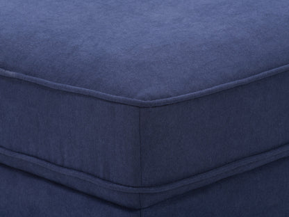 Navy blue mid-century modern ottoman with tufted fabric and wooden legs.