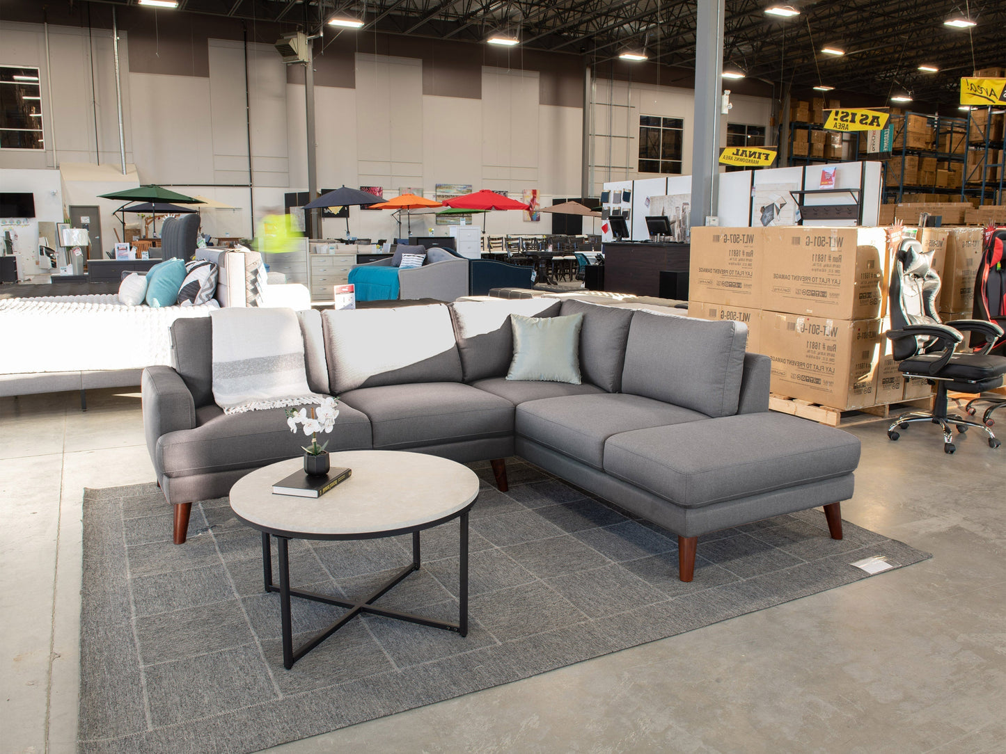 Dark grey sectional sofa, right facing, with tufted cushions and wooden legs, perfect for modern living rooms.