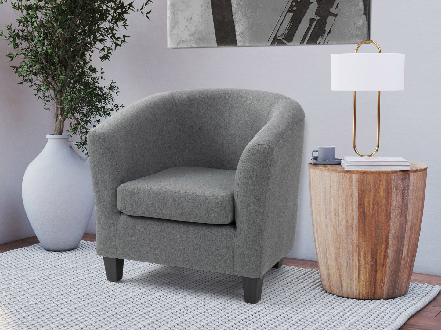 Grey tub accent chair with wooden legs, tufted backrest, and soft fabric upholstery.