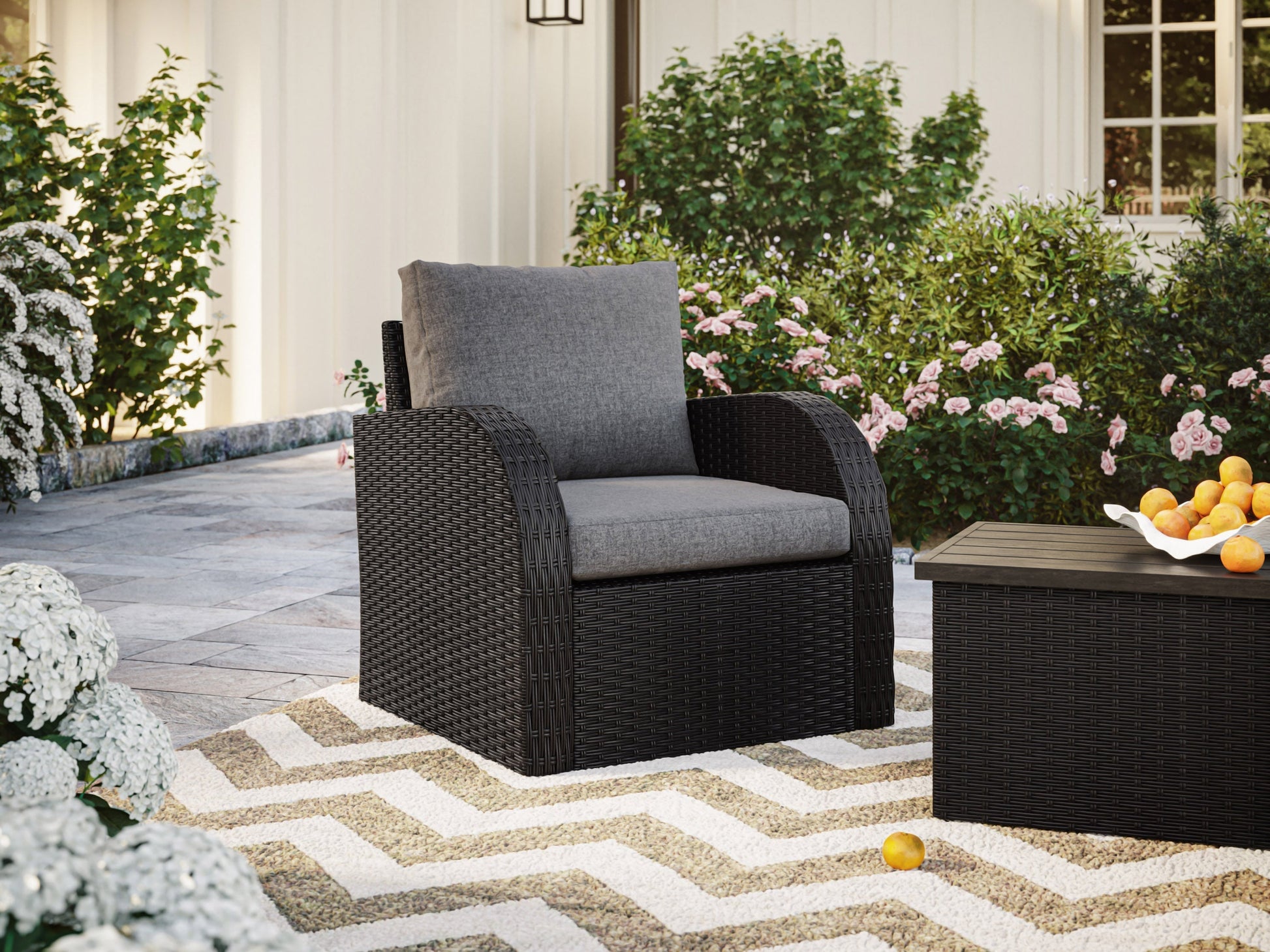 Grey outdoor wicker patio chair with comfortable cushions and sturdy metal frame.