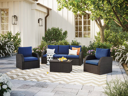 Outdoor blue patio conversation set with cushions, wicker frame, and glass-top coffee table for garden or deck.