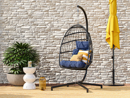 Blue hanging egg chair with cushioned seat, wicker design, and sturdy metal stand for patio use.