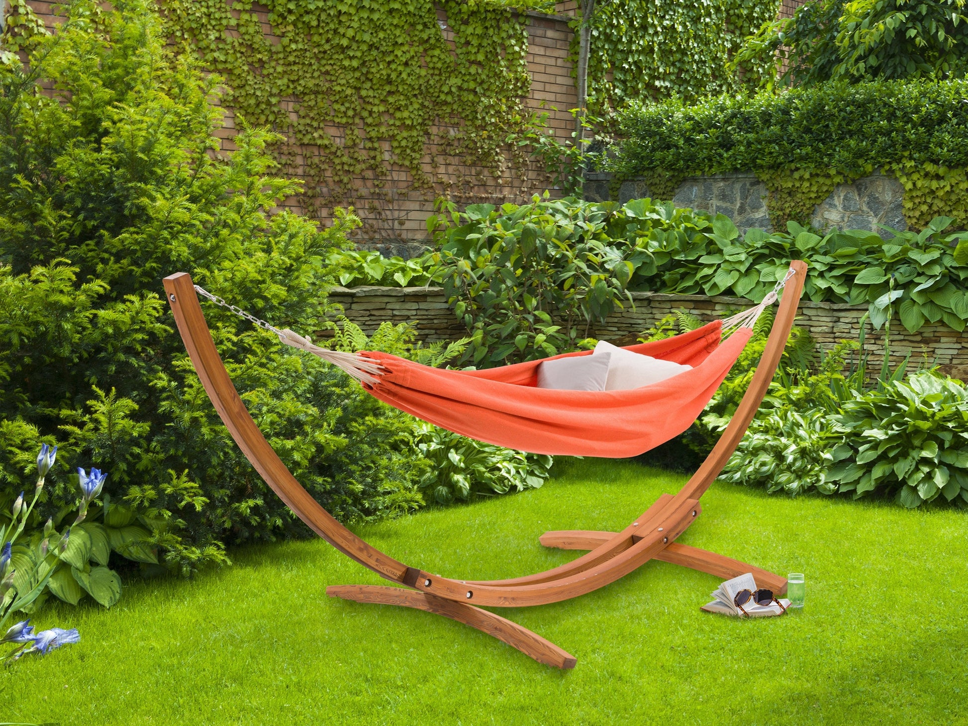 Orange hammock with wooden stand, perfect for patios, featuring durable fabric and a stylish curved design.