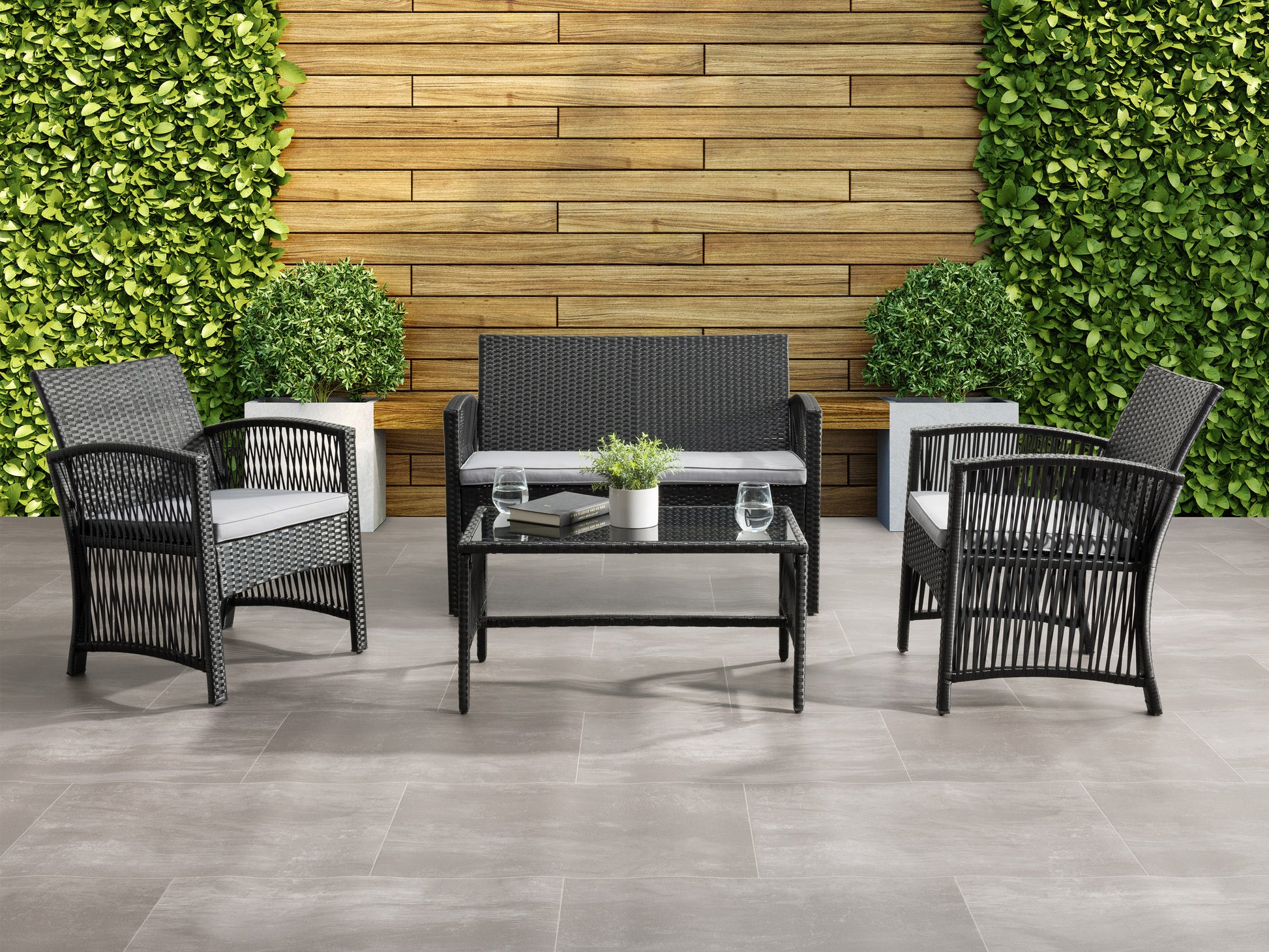 4-piece patio conversation set with grey cushioned seats, dark brown wicker frames, and a tempered glass coffee table, perfect for outdoor lounging and entertaining.