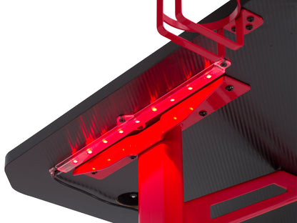 Red and black gaming desk with LED lights, featuring a sleek carbon fiber texture, built-in cup holder, headphone hook, and cable management system, perfect for an organized and immersive gaming setup.